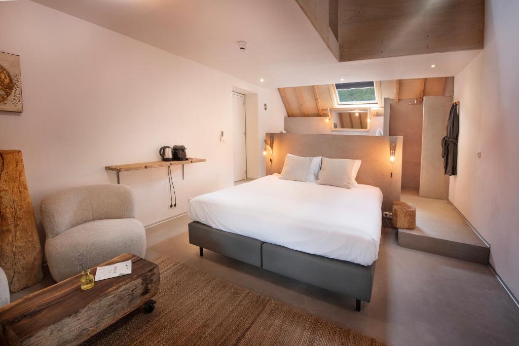 een slaapkamer met een wit bed en een stoel bij B&B Le Rêve Maastricht in Maastricht