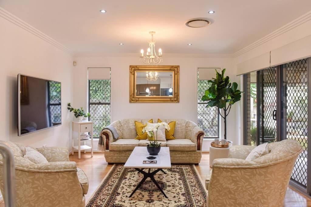 a living room with a couch and chairs and a table at The Arcadia - Entire Luxurious English Cottage With Huge Privacy Near CBD in Springfield Lakes