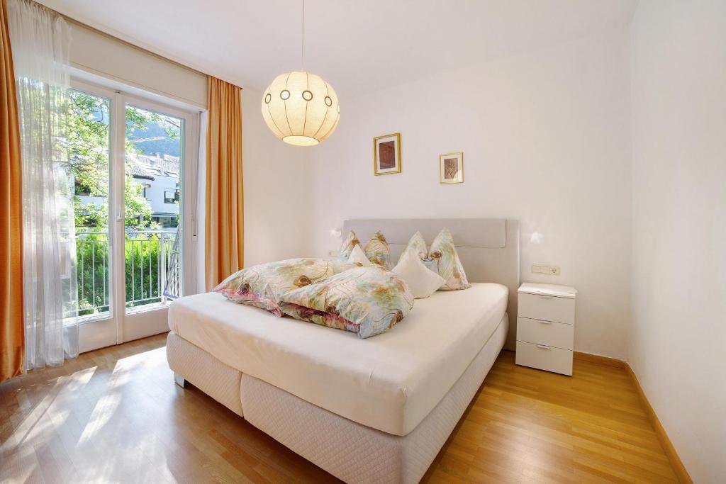 um quarto branco com uma cama e uma janela em Villa Sabine - Karin em Merano