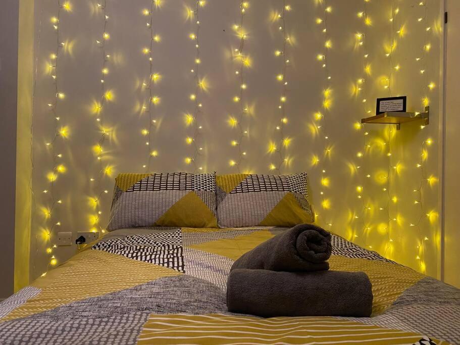 sypialnia z łóżkiem z oświetleniem na ścianie w obiekcie Flat by Victoria park - with balcony w Londynie