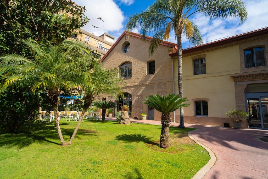 a building with palm trees in front of it at DWO Valencia in Valencia