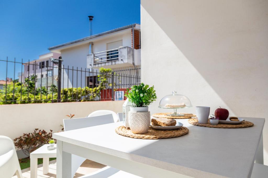 uma mesa branca com dois pratos de comida em Melania Holidays Home - Sole Incantatore em Santa Maria Navarrese