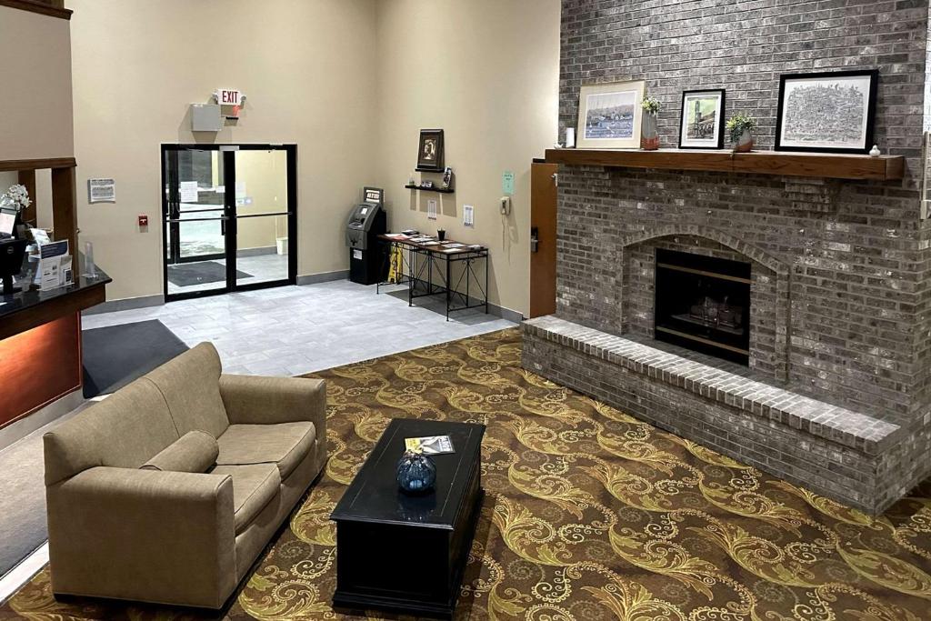 a living room with a couch and a fireplace at Quality Suites Near West Acres in Fargo