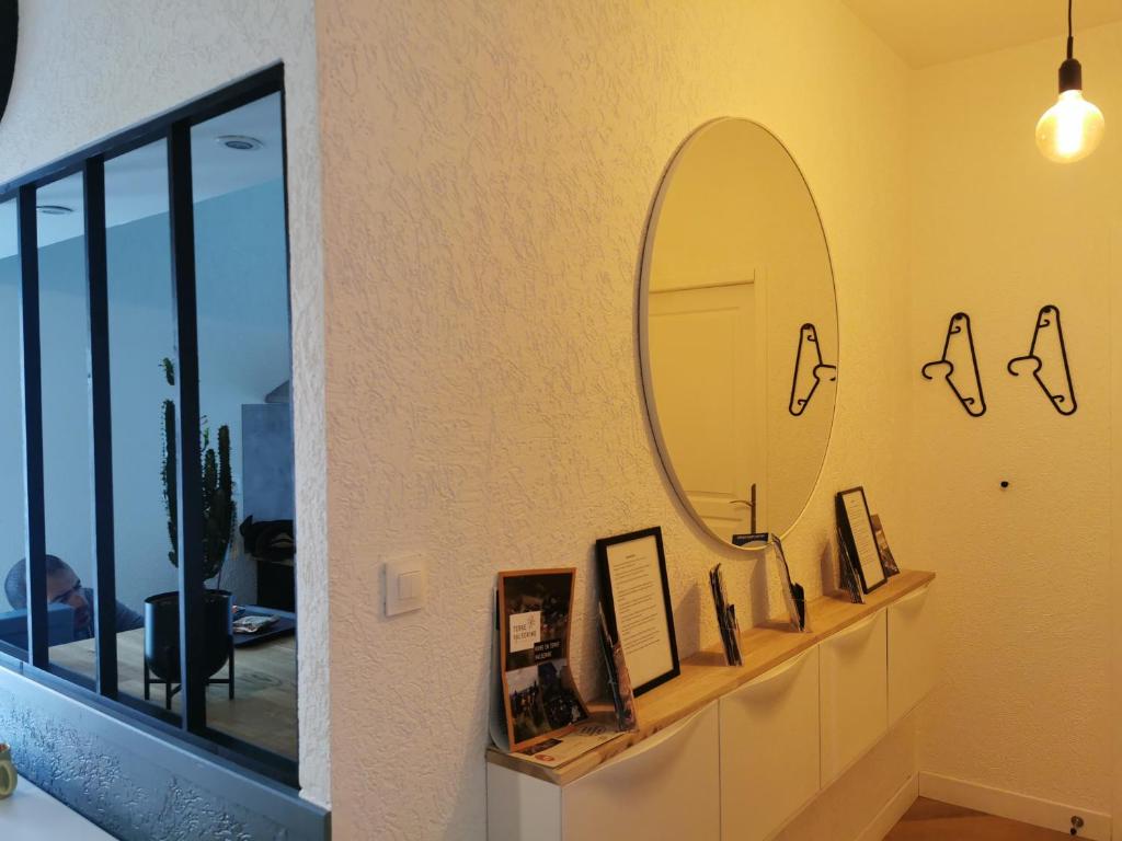 lustro na ścianie ze zdjęciami na półce w obiekcie LE PETIT ANGLE APPARTEMENT 2 Pièces, plein centre ville, près de la gare jusqu'à 4 personnes w mieście Bellegarde-sur-Valserine