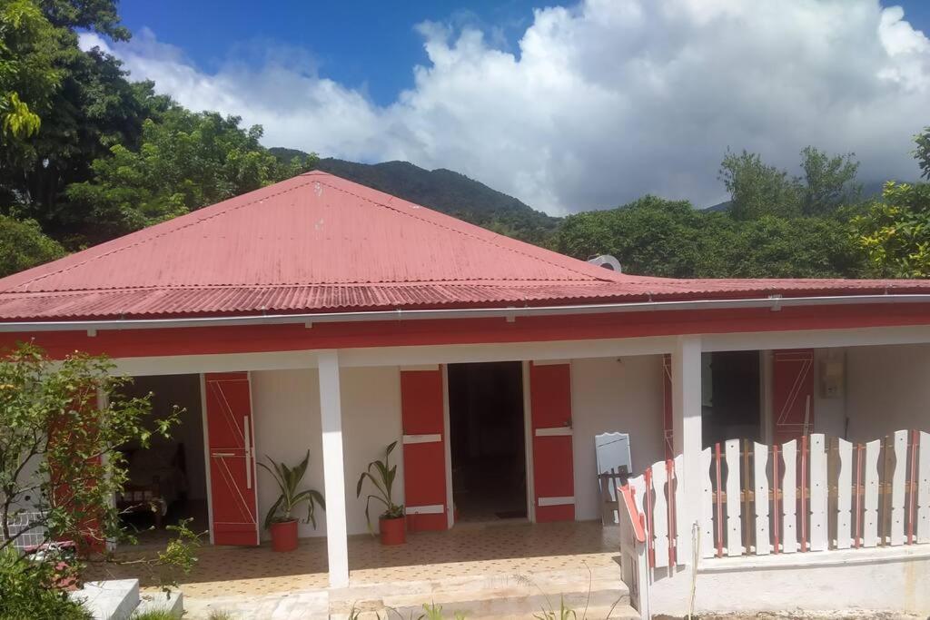 une maison rouge et blanche avec un toit rouge dans l'établissement Maison familiale et authentique, à Vieux-Habitants