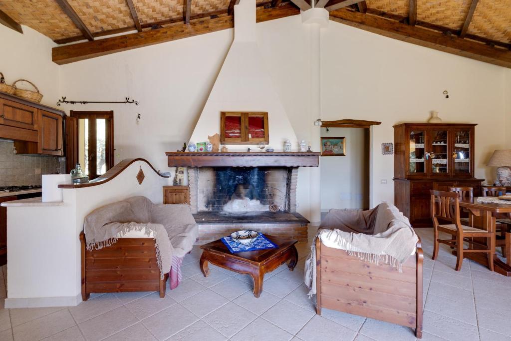 uma sala de estar com uma lareira e uma mesa em Vivi Natura em Marrùbiu