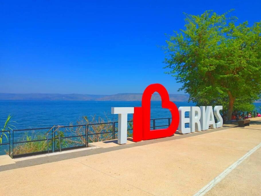 een bord voor een resort met de oceaan op de achtergrond bij Loft Tiberiade in Tiberias