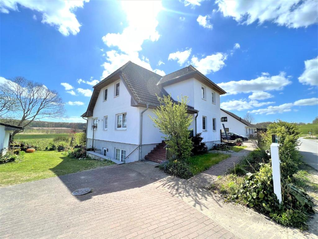 una gran casa blanca con entrada para coches en Ferienwohnung Rabennest, en Binz