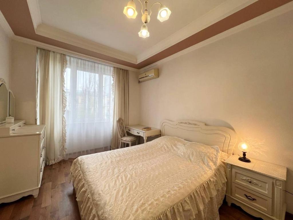 um quarto com uma cama branca e uma janela em Apartments near Arena City em Kiev