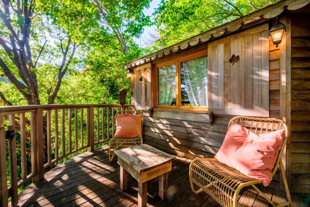 a porch of a cabin with two chairs and a bench at King Louie and Mowgli in Saint-Paul-de-Vence