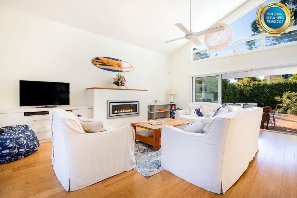 a living room with white furniture and a flat screen tv at Sapphire Sands - Pet Friendly - Community Pool in Callala Beach