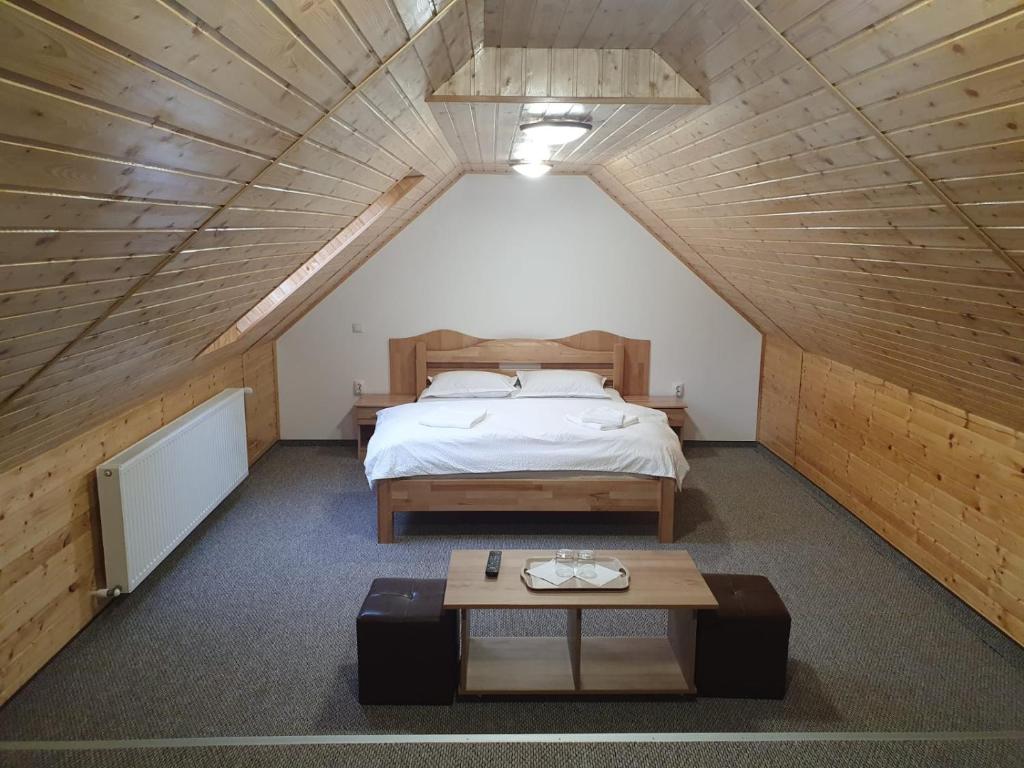 1 dormitorio en el ático con 1 cama y 1 mesa en Casa Miruna & Noris, en Bran