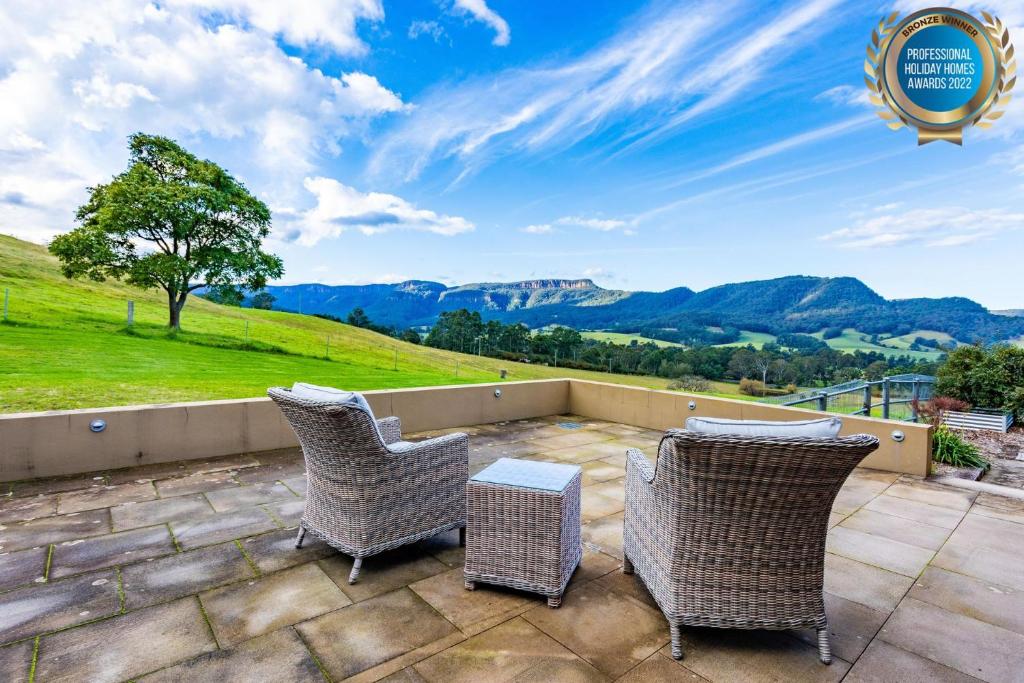 a patio with chairs and a view of mountains at The Dairy at Cavan I Kangaroo Valley I Stunning Views in Barrengarry