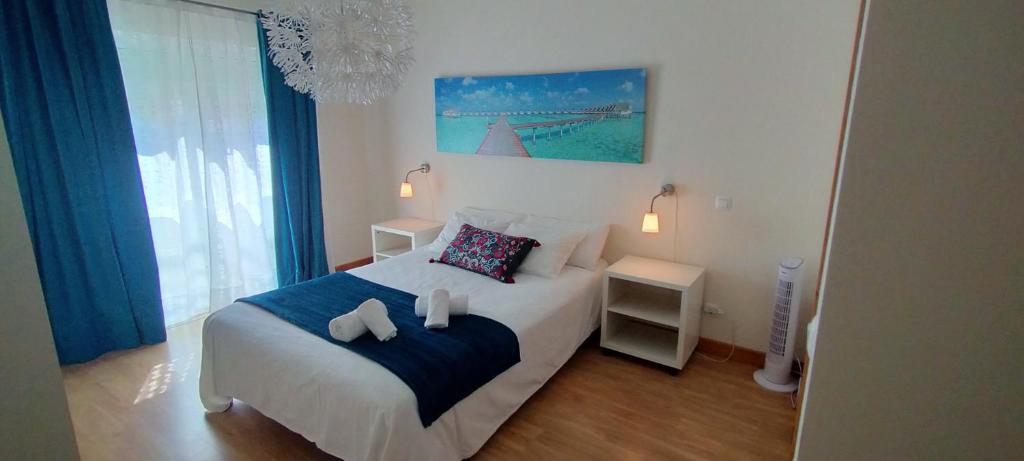 a bedroom with a bed with two towels on it at MAHGIC Beach Apartment in Cabanas de Tavira