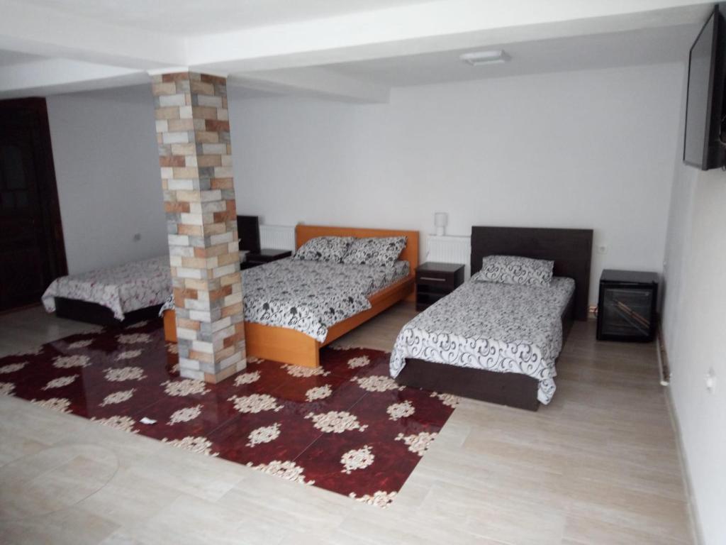 a room with three beds and a brick pillar at Casa Rariana in Călimăneşti