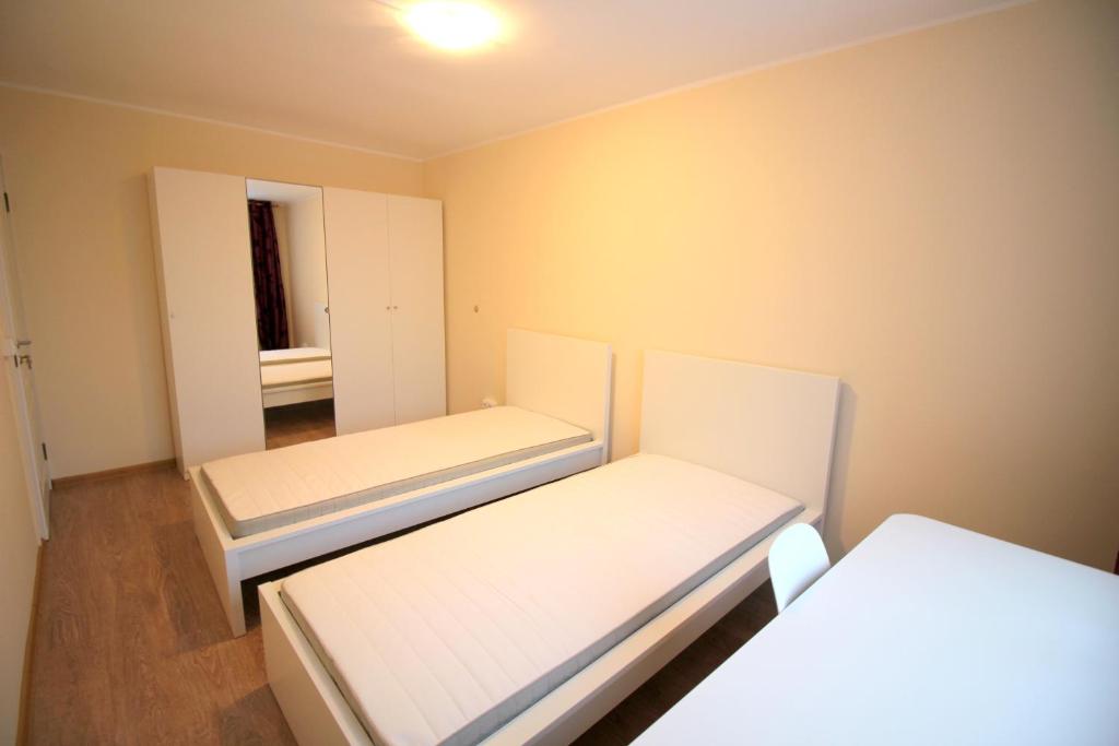 een kleine kamer met 2 bedden en een spiegel bij Varpo st 10 Kaunas Students Home LT in Kaunas