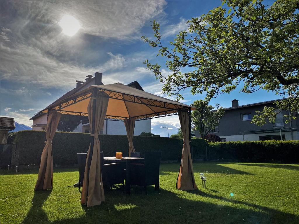 cenador con mesa y sillas en un patio en Haus im Seegebiet von Villach en Villach