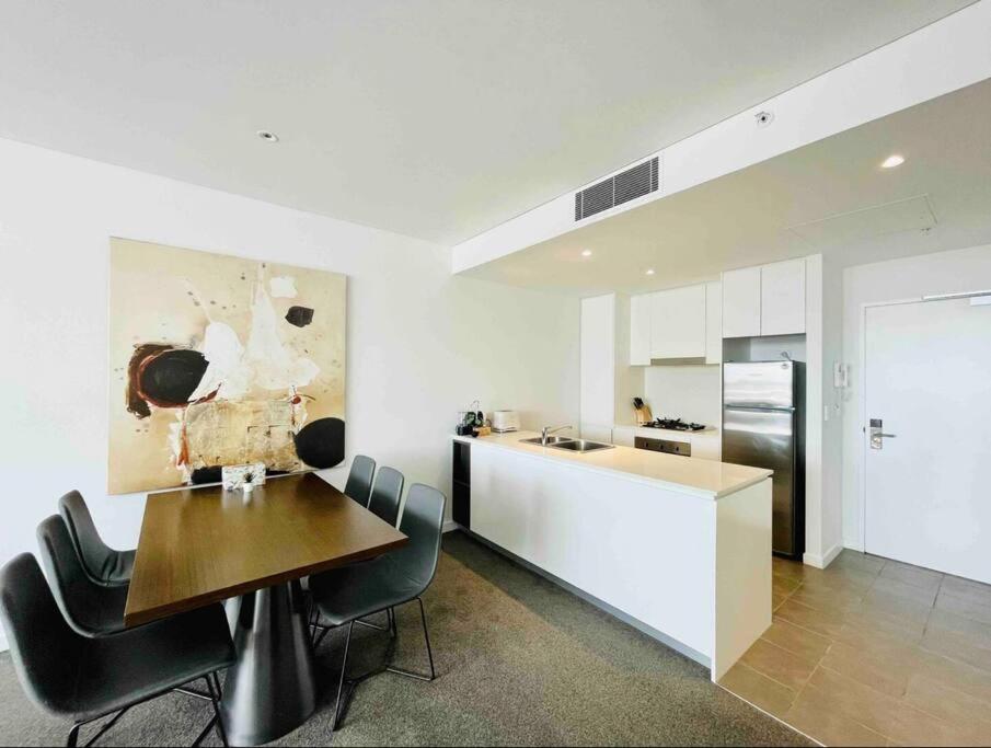 een keuken en eetkamer met een tafel en stoelen bij Chatswood Exeutive Suites - 3beds2baths in Sydney