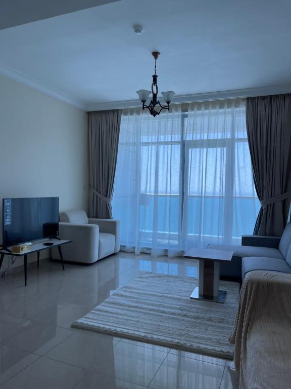 a living room with a couch and a table at Lovely 2 BHK just 2 min from the beach in Ajman 