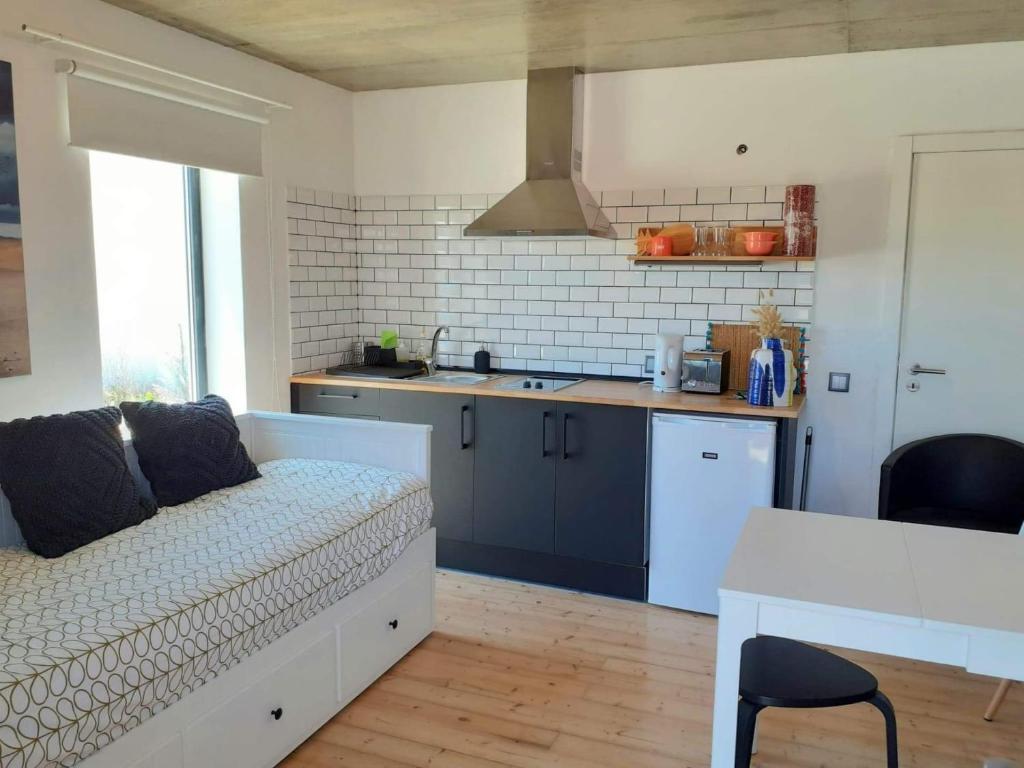 een woonkamer met een bank en een keuken bij ZENergy - GUEST HOUSE in Odeceixe