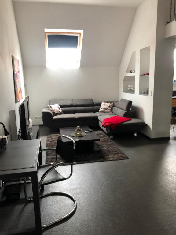 a living room with a couch and a table at À proximité de Strasbourg in Kilstett