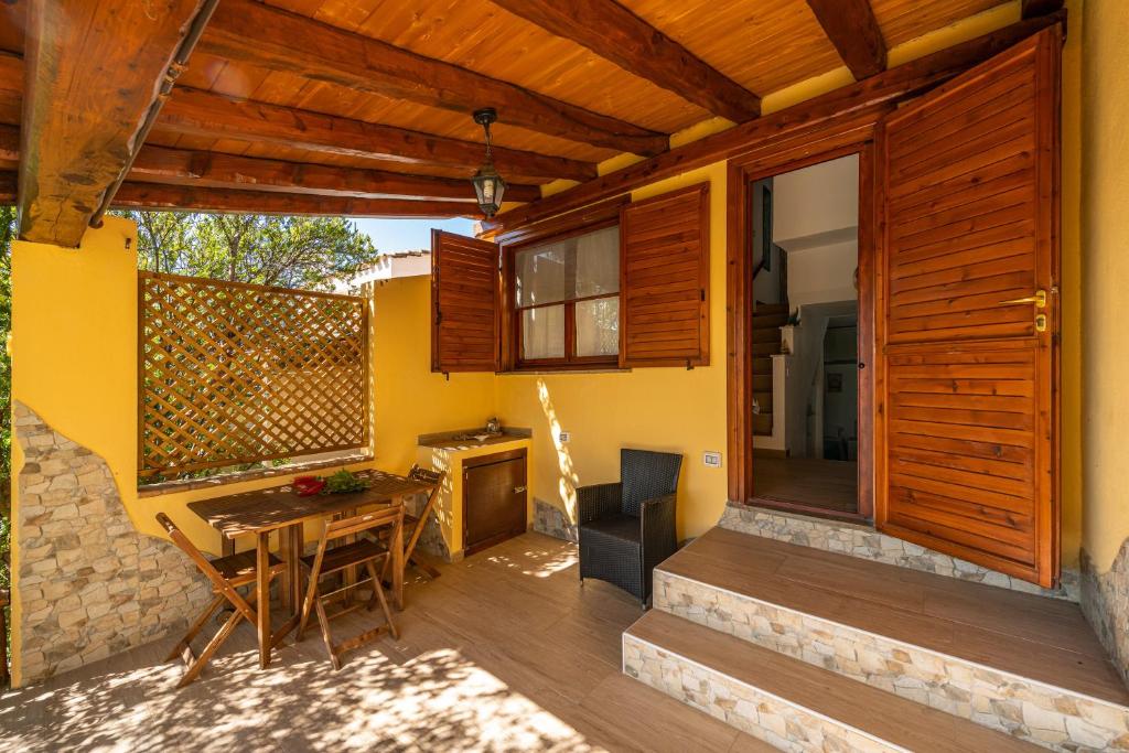 um pátio com uma mesa e uma lareira numa casa em Porto Luna em Villasimius