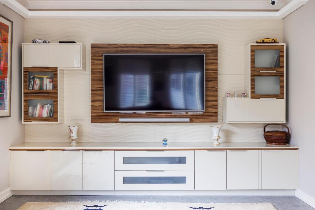 a living room with a television on a wall at Londonese House in Chelsea in London