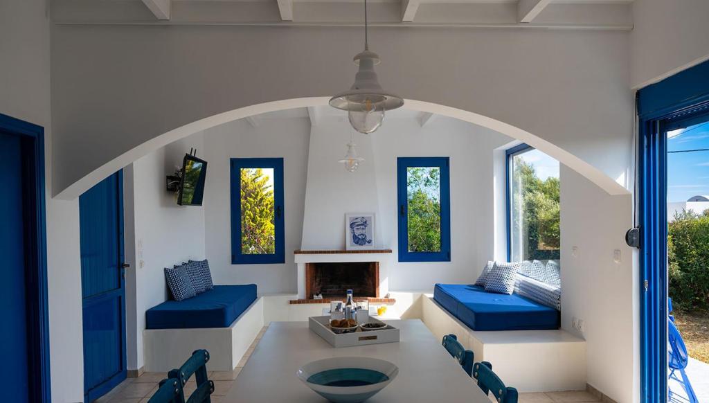 a living room with blue chairs and a fireplace at Evelia Sea House in Plimmiri