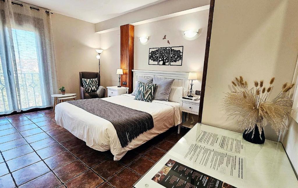 Un dormitorio con una cama y una mesa con un libro en Hotel Medina de Toledo, en Toledo