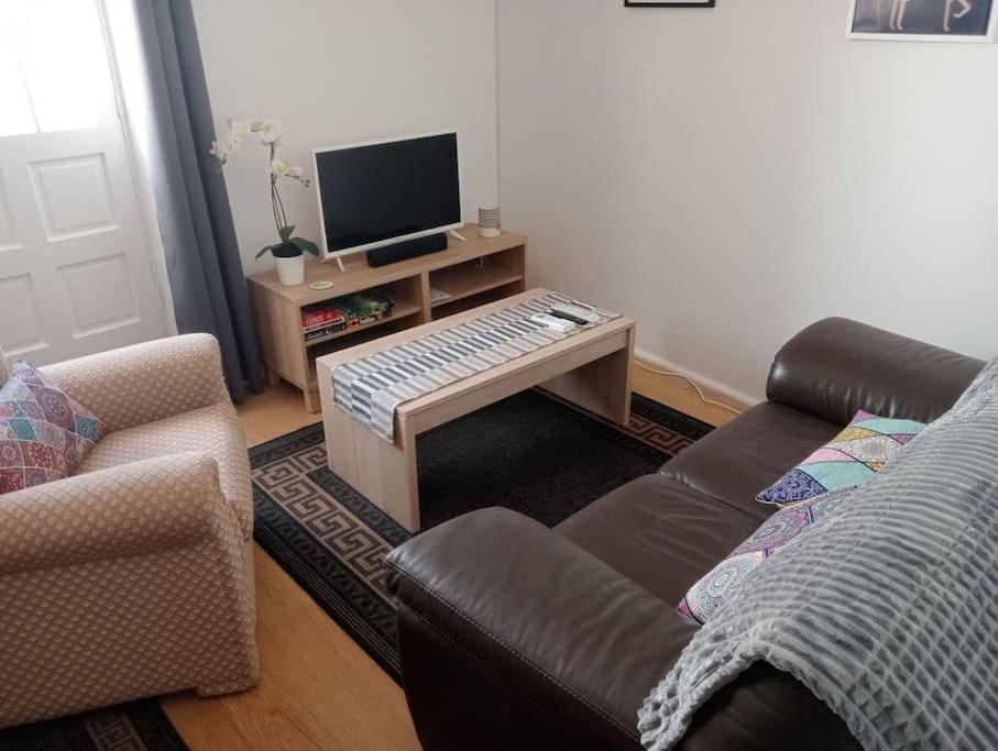 a living room with a couch and a television at The Corner Terraza in Alcaudete