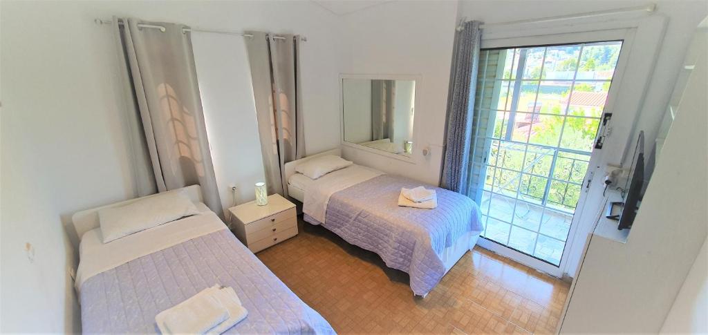 Habitación pequeña con 2 camas y ventana en Vacation and Relaxation Home Oropos, en Néa Palátia