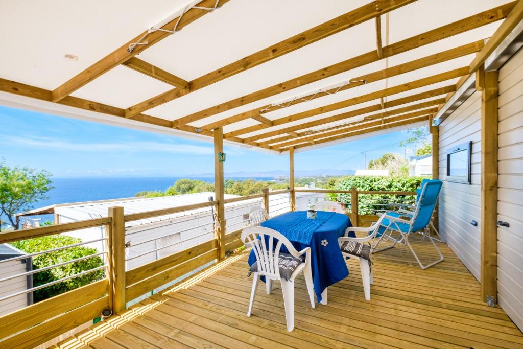 una terraza de madera con una mesa azul y sillas. en Mobile-home Baia en Saint-Raphaël