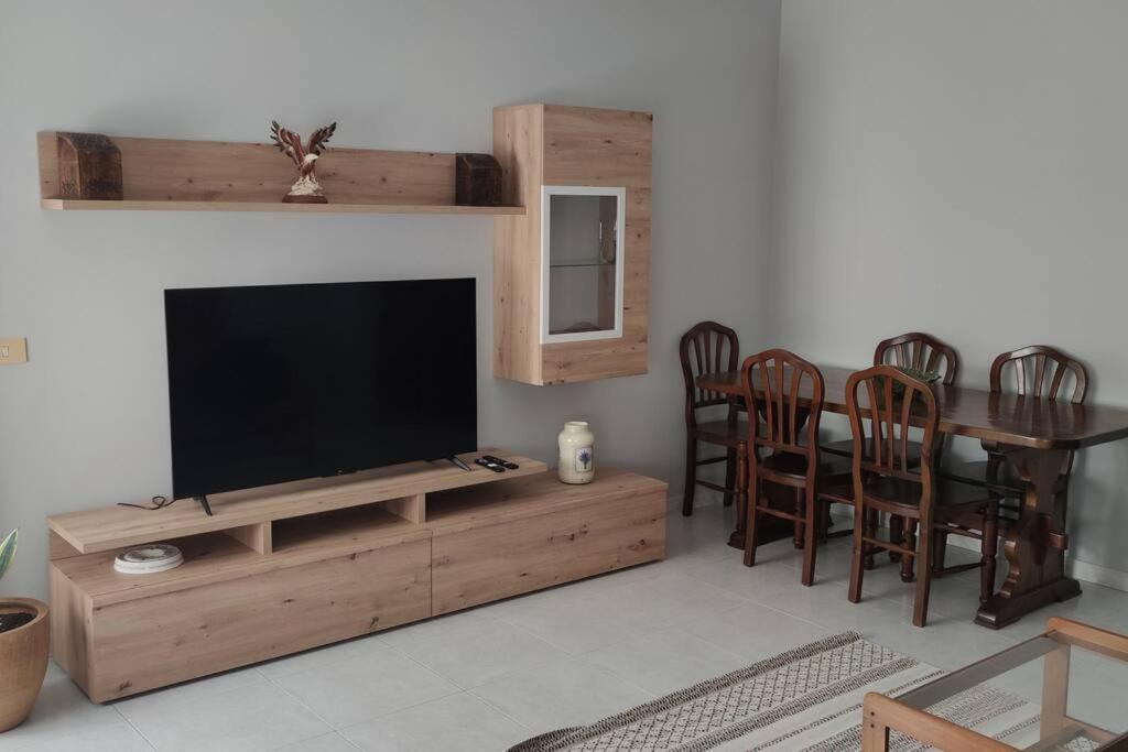 uma sala de estar com uma televisão e uma mesa e cadeiras em Piso turístico Dena em Pontevedra