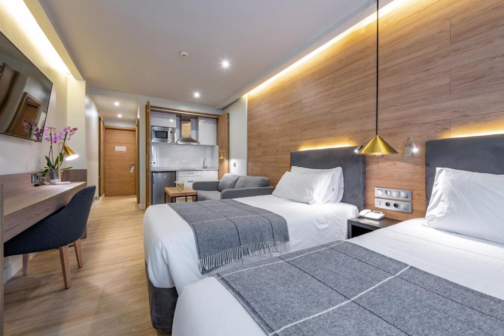 Habitación de hotel con 2 camas y escritorio en Espahotel Plaza de España, en Madrid