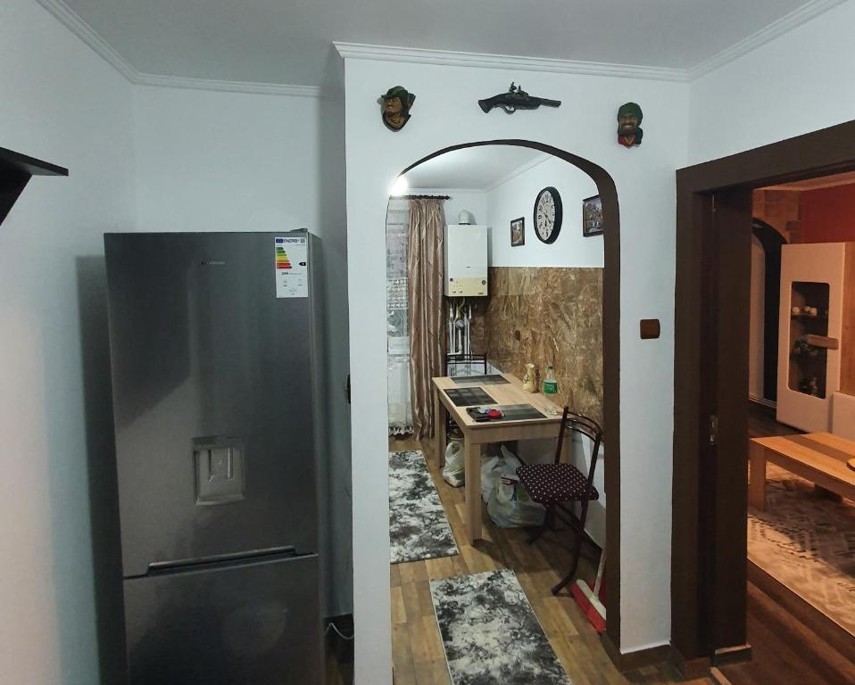 a kitchen with a stainless steel refrigerator and a table at Casa & Julieta in Tecuci