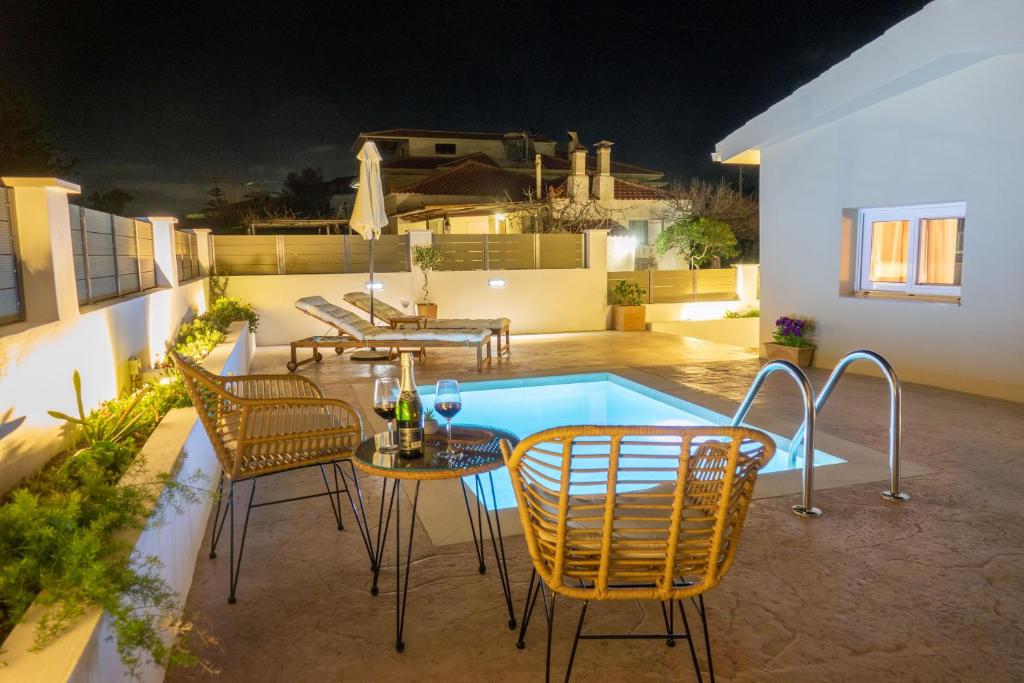 a patio with chairs and a table and a swimming pool at Anatolikos Beach House in Alykes
