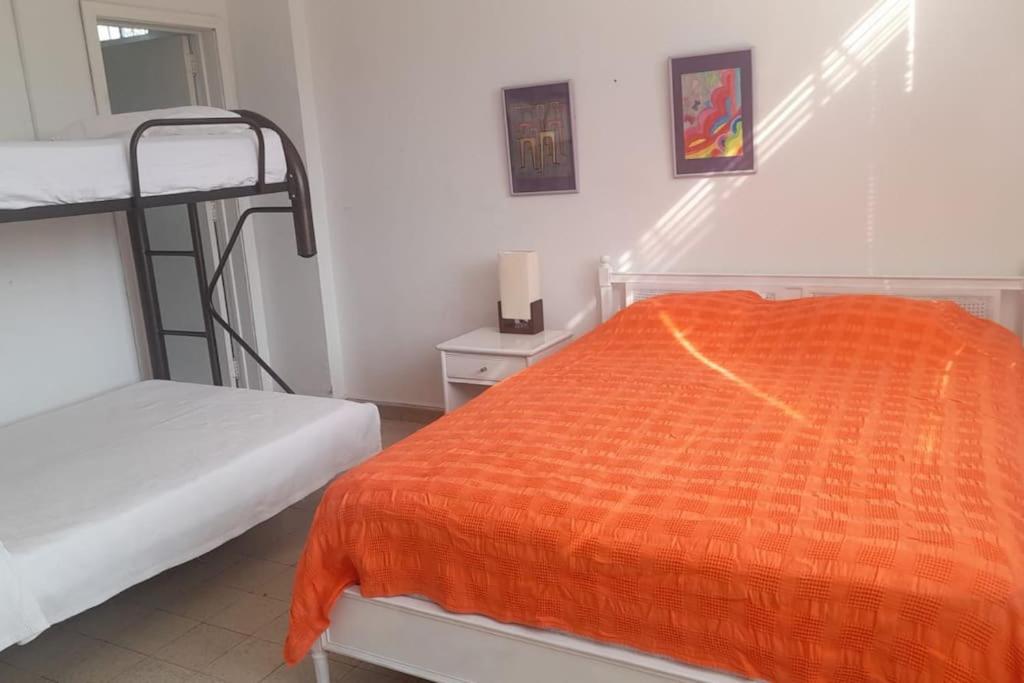 a bedroom with two bunk beds and an orange blanket at casa con piscina aeropuerto flandes in Flandes