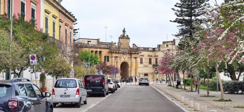 een straat met auto's geparkeerd voor een gebouw bij Family and friends house in Lecce