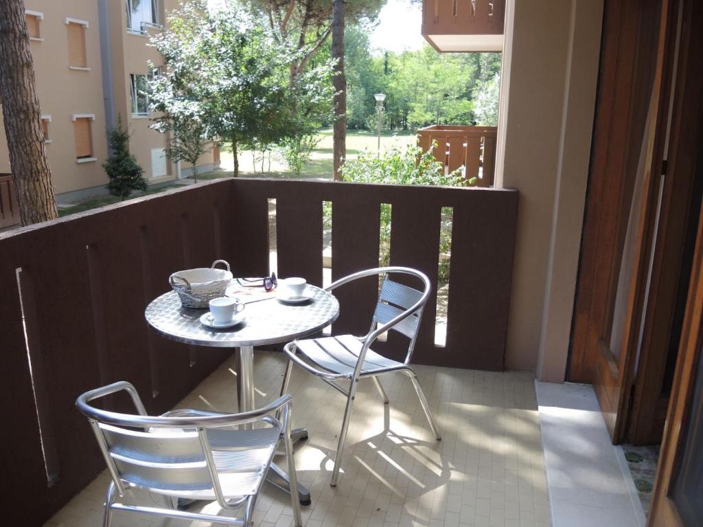 a table and two chairs sitting on a balcony at Nice flat with terrace in a great spot - Beahost in Bibione