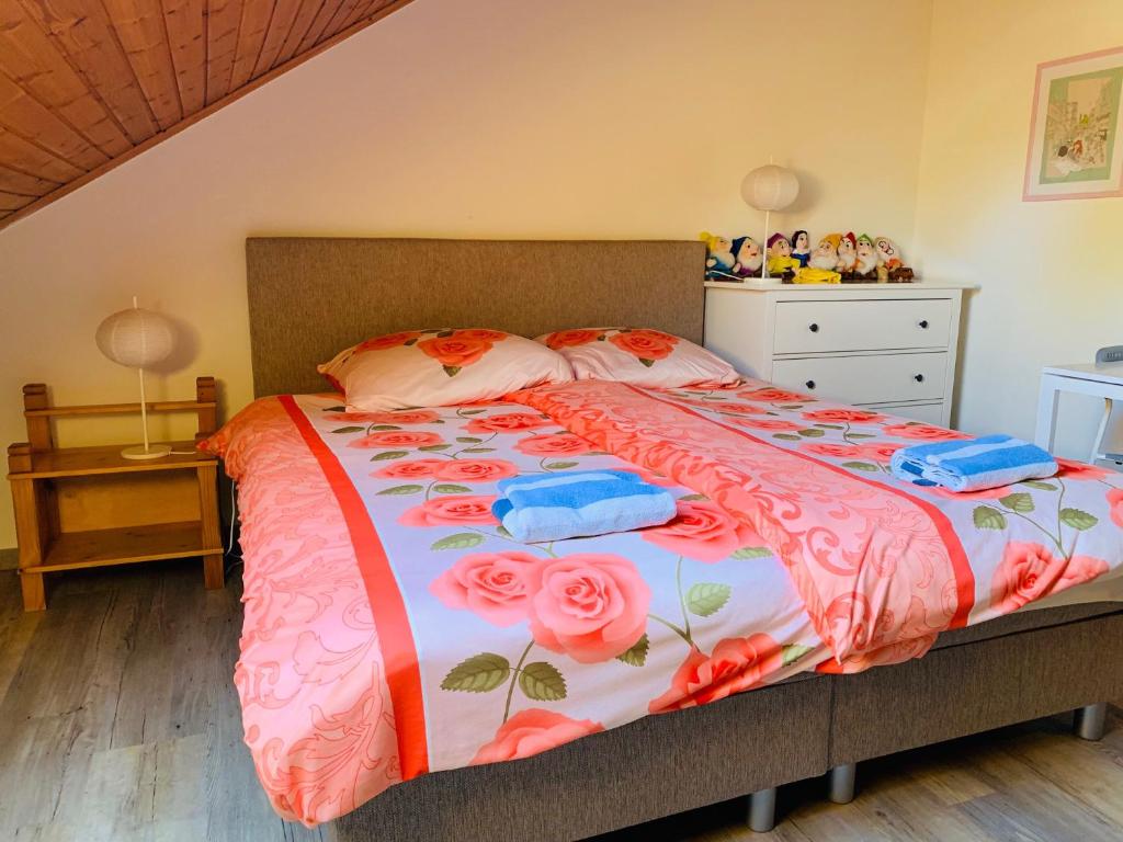 a bedroom with a bed with pink flowers on it at B&B Oostkapelle aan Zee in Oostkapelle