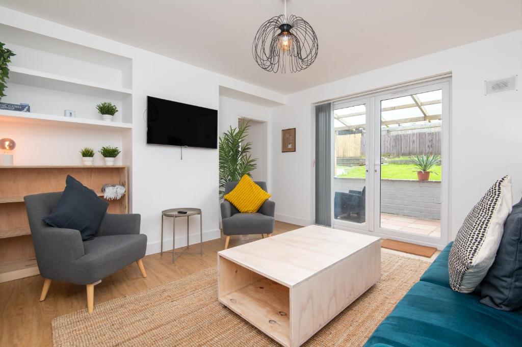 uma sala de estar com um sofá e cadeiras e uma televisão em Brett Stays - King Weston Abode em Avonmouth