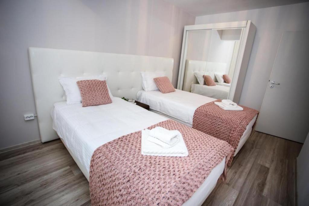 two beds in a room with a mirror at Metropolitan Iassium Apartments in Iaşi