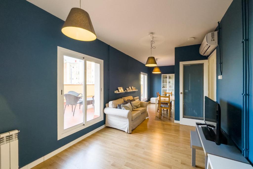 salon z niebieskimi ścianami i kanapą w obiekcie AinB Barcelona Sants Apartments w Barcelonie