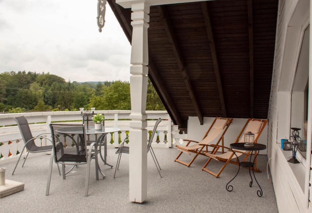 eine Terrasse mit einem Tisch und Stühlen auf dem Balkon in der Unterkunft Ferienwohnungen Weitmann in Ockfen