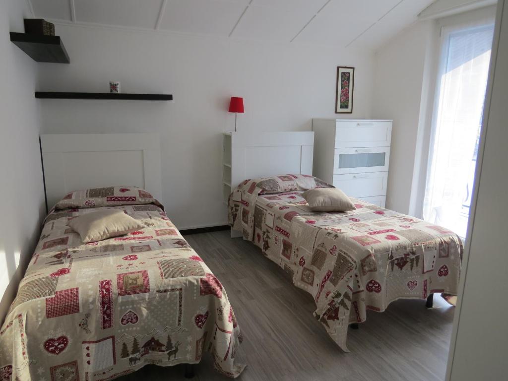 a bedroom with two beds and a window at CASA MICHELA BB OSSOLA PARKING FREE in Domodossola