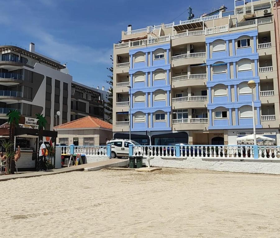 トレビエハにあるLa Playa Blanca - Palacio del Mar, BEACH, SEA VIEW, POOLの一部の建物の隣にあるビーチ沿いの青い建物