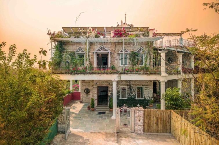 an old house with flowers on top of it at Moonstone, Bhopal, amã Stays & Trails in Shamsgarh