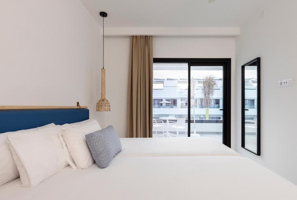 a bedroom with a white bed and a large window at Esmeralda Cotillo Homes by LIVVO in El Cotillo