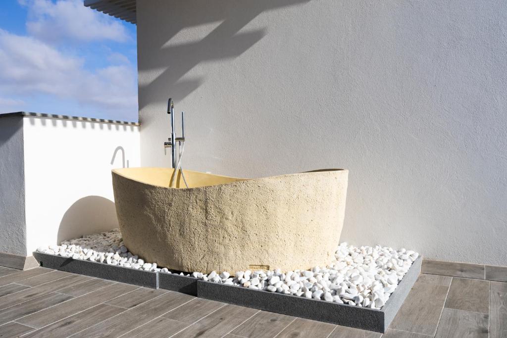 a bath tub sitting on top of a pile of rocks at Esmeralda Cotillo Homes by LIVVO in El Cotillo