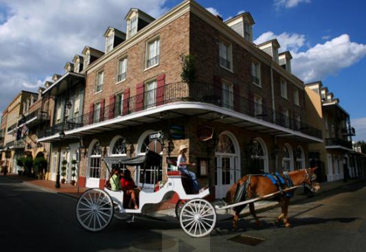 un carruaje tirado por caballos frente a un edificio en Maison Dupuy Hotel, en Nueva Orleans